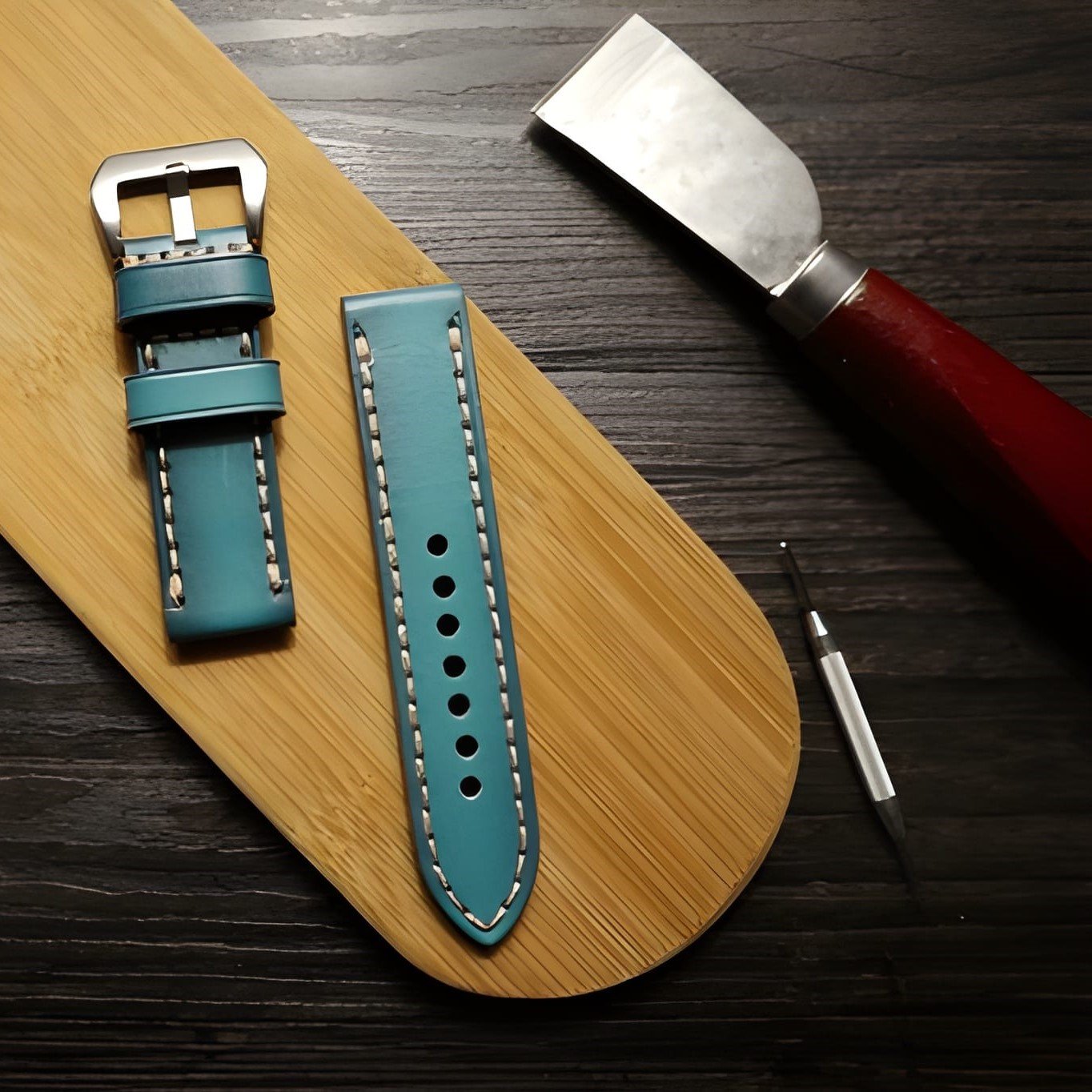 Professioneller Uhrenarmband-Service in Langenfeld: Hochwertiges blaues Lederarmband mit handgefertigten Nähten neben Werkzeugen für die präzise Anpassung und Kürzung.