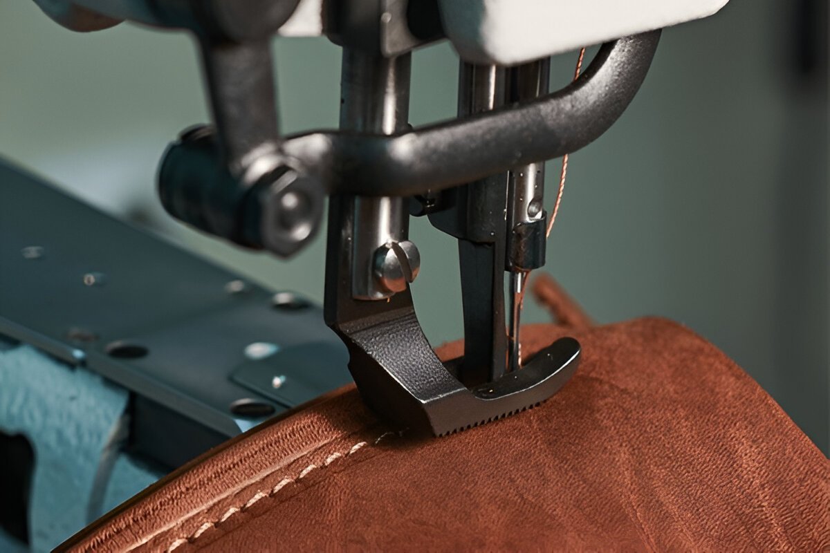 Fachgerechte Ledernäharbeiten in Langenfeld: Eine schwere Industrienähmaschine verarbeitet dickes braunes Leder für maximale Haltbarkeit.
